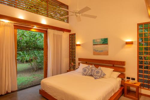 a bedroom with a bed and a window at Tres Lodge Villa - Shared Pool - Natural Setting in Cocles