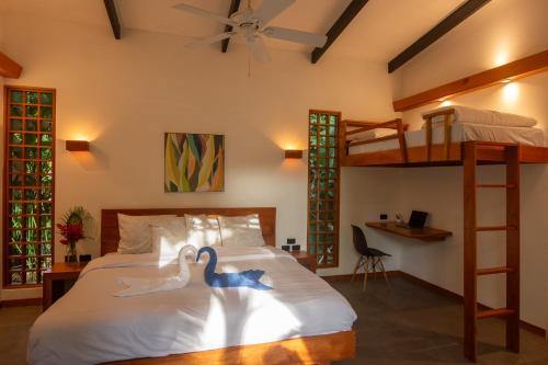 two swans on a bed in a bedroom with a bunk bed at Villa Tucán Pool - 10-Min Walk to Shore in Cocles