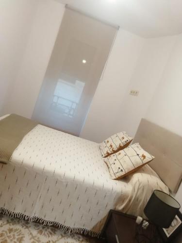 a bedroom with a white bed with pillows on it at Casa Regina Baiona ideal familias Peregrinos y parejas, cerca del camino y de la playa in Baiona