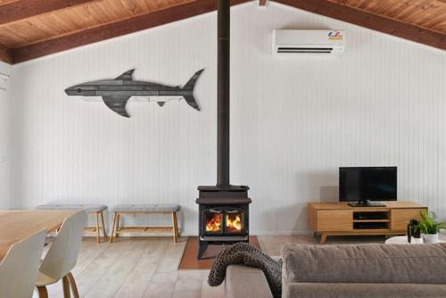 a living room with a fireplace with a shark on the wall at Sunset Sanctuary 500m to beach Pet Friendly in Torquay