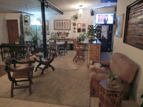 a living room with a couch and chairs and a table at Pousada Casa Jardim in Serra Negra