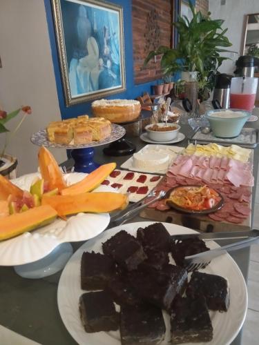 a table with many plates of food on it at Pousada Casa Jardim in Serra Negra
