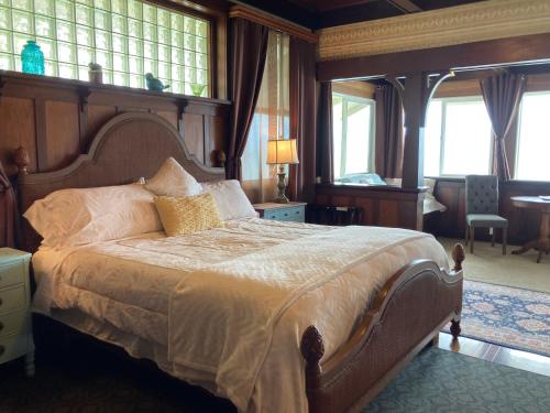 una camera con un grande letto in una stanza con finestre di Hilo Bay Oceanfront Bed and Breakfast a Hilo