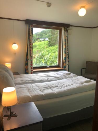 a bedroom with a large bed with a window at Jølster Lake View in Årdal