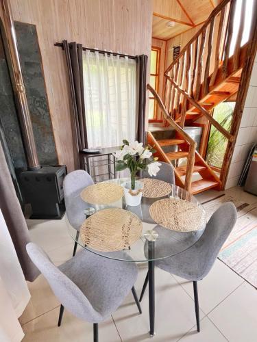 a dining room with a glass table and chairs at Cabañas de la Barra in Villarrica