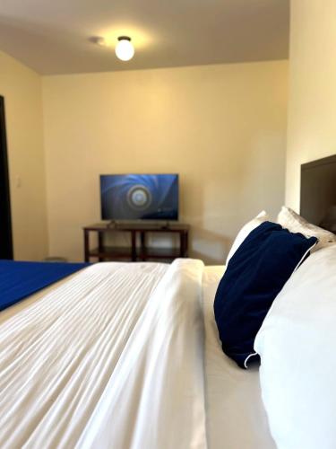 a bedroom with a bed with a television in the background at Villa Salento Boutique Apartments & Spa in Salento