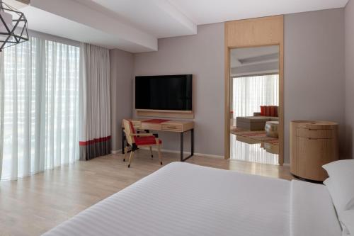 a bedroom with a television and a desk with a chair at Marriott Marquis Dubai Creek in Dubai