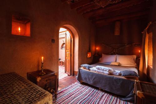 a bedroom with a bed and an arched doorway at Kasbah Tebi in Aït Ben Haddou