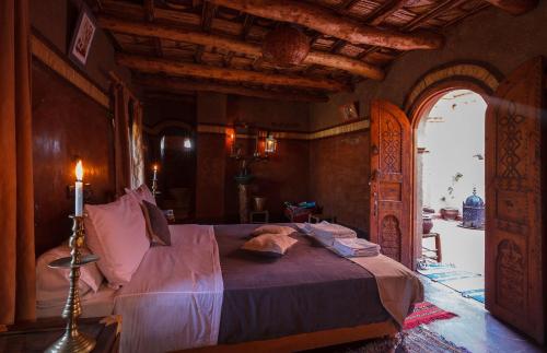 
a bed in a room with a large window at Kasbah Tebi in Aït Ben Haddou
