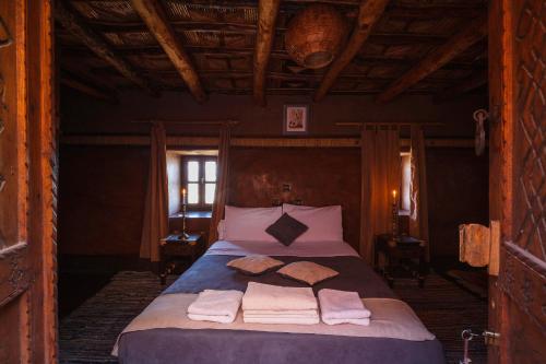 
a bedroom with a bed and a dresser at Kasbah Tebi in Aït Ben Haddou
