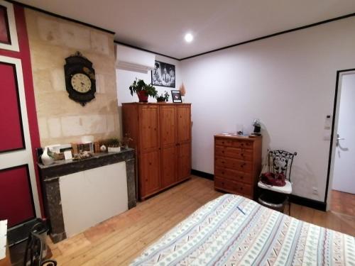 une chambre avec un lit et une horloge au mur dans l'établissement chambre d'hôte 50, rue Gambetta à Libourne, à Libourne