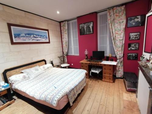 une chambre avec un lit et un bureau avec un ordinateur dans l'établissement chambre d'hôte 50, rue Gambetta à Libourne, à Libourne