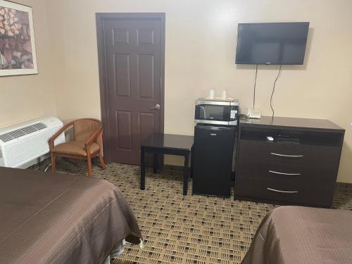 a hotel room with a bed and a television and a desk at Economy Inn & Suites in Ashtabula
