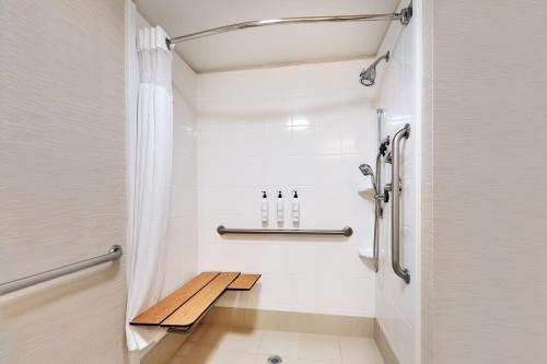 a small bathroom with a bench in the shower at Fairfield Inn by Marriott Lexington Park Patuxent River Naval Air Station in Lexington Park