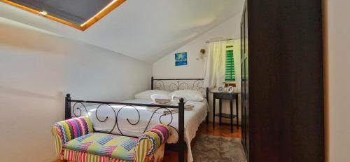ein Schlafzimmer mit einem Bett und einem Stuhl in der Unterkunft Promaja in Kaštela