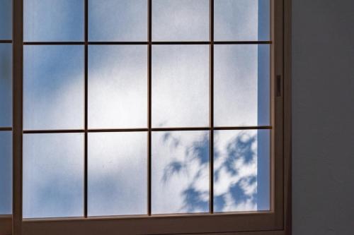a window with a blue sky and a tree at Juju Kiseki House in Naoshima