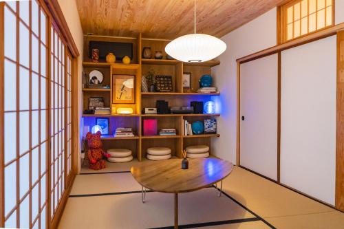 a room with a table and a book shelf at Juju Kiseki House in Naoshima