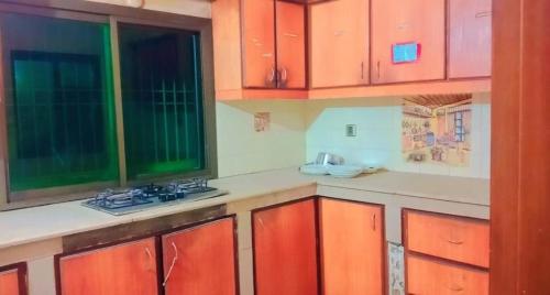 a kitchen with orange and green cabinets and windows at Family Guest House in Gulshan-e-iqbal , block-10 in Karachi