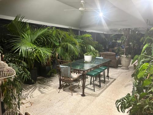 a table and chairs in a patio with plants at Koombana Retreat in Perth