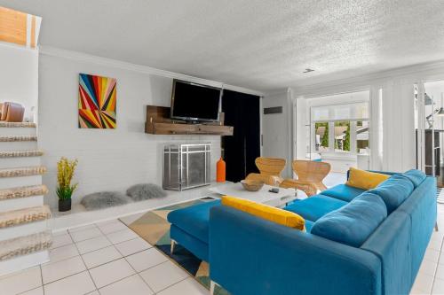 a living room with a blue couch and a tv at Upscale Modern Home with perfect triad location in High Point