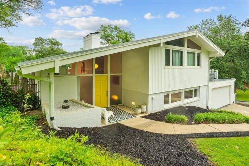 a small green house with a yellow door at Upscale Modern Home with perfect triad location in High Point