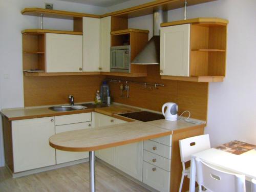 cocina con armarios blancos y encimera de madera en Apartament Super Poznań, en Poznan