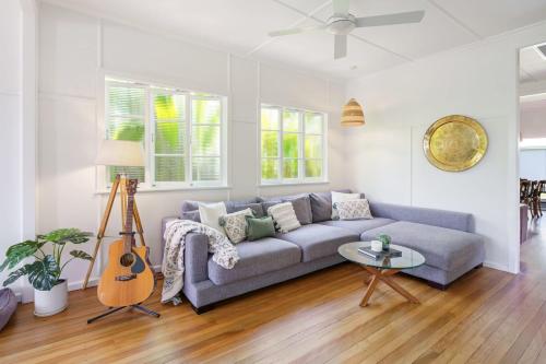 sala de estar con sofá y guitarra en Beach Bliss at Moffat Beach, en Caloundra