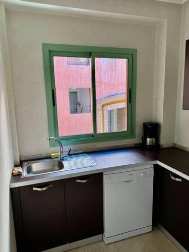 a kitchen with a sink and a window at Beautiful Hivernage Apartment with Pool & Balcony, Near Attractions in Marrakech