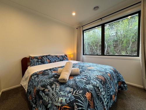 a bedroom with a bed with a large window at NO PARTY ALLOWED, Entire Brand New 3 bedroom townhouse, free unlimited fibre wifi and free parking in Wellington