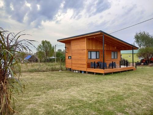 a small wooden cabin in a grass field at El ranchito in Colón