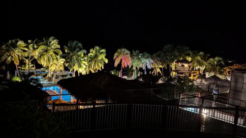 a resort with palm trees and a pool at night at Ti Roc Studio in Le Diamant