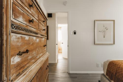 a large wooden dresser in a bedroom with a bed at Wabi Sabi SoCo Retreat- Relax, Work and Soak in the Pool in Austin