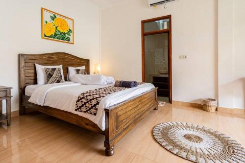 a bedroom with a large bed and a rug at Villa Pondok Joglo in Yogyakarta