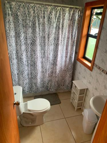 a bathroom with a toilet and a sink at Casa de campo con tinaja en Los Ángeles in Los Ángeles