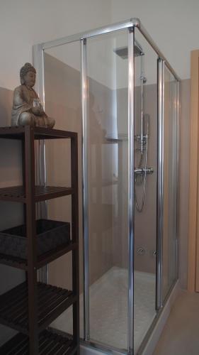a glass shower stall with a statue on a shelf at Provenzale in Desenzano del Garda