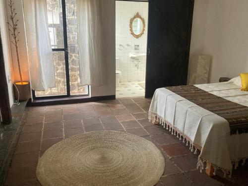 a bedroom with a bed and a bathroom with a tub at Casa Café Arte in Tepoztlán