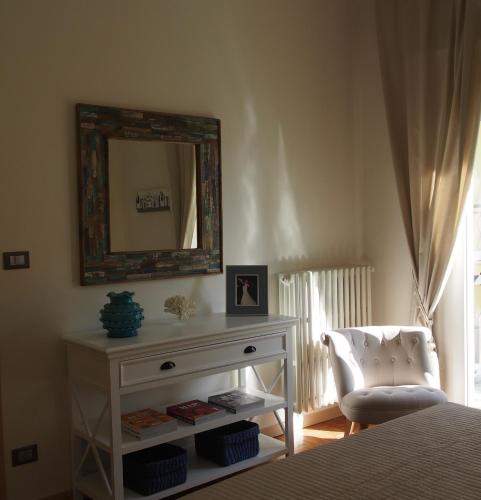 a bedroom with a dresser and a mirror and a chair at Provenzale in Desenzano del Garda