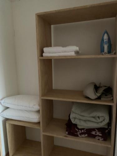 a closet with wooden shelves with towels and towels at Casa de campo con tinaja en Los Ángeles in Los Ángeles
