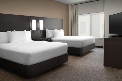 a hotel room with two beds and a flat screen tv at Residence Inn by Marriott Galveston Island in Galveston