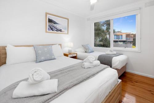 een slaapkamer met twee bedden en een raam bij A Vue De Rye in Rye