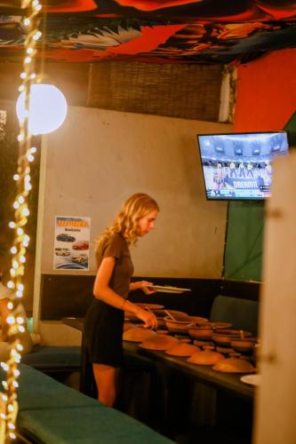 a woman standing in a kitchen preparing food at Hangover Hostels Mirissa in Mirissa