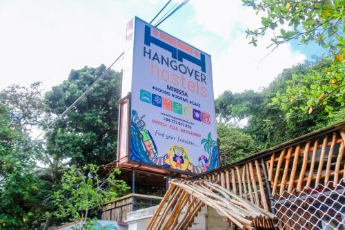 a sign on the side of a building at Hangover Hostels Mirissa in Mirissa