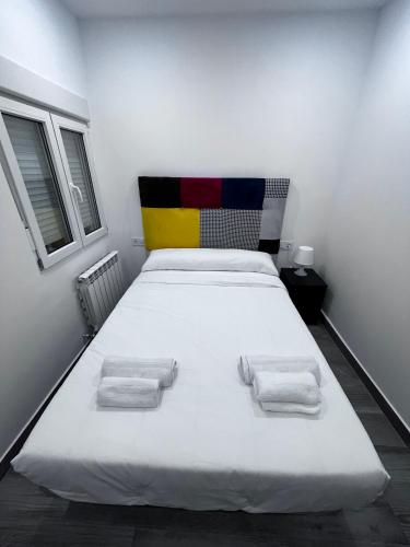 a bedroom with a large white bed with two towels at Habitación turística en Irún in Irún