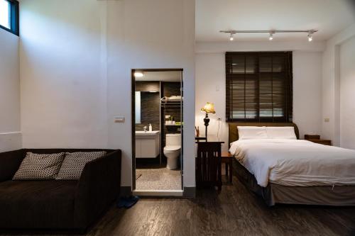 a bedroom with a bed and a couch and a bathroom at whitesun in Jian