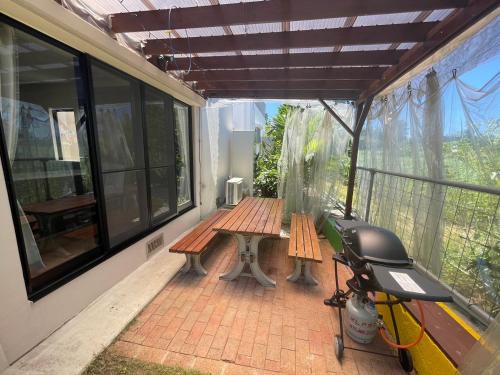 a screened in porch with a bench and a picnic table at Sun Floralは古宇利島まで3分で完全プライベート1棟貸 in Nago