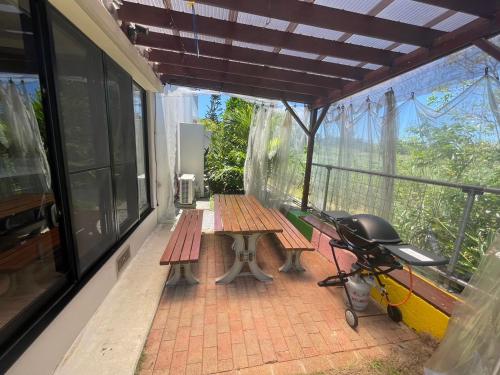 a porch with a picnic table and a stroller at Sun Floralは古宇利島まで3分で完全プライベート1棟貸 in Nago