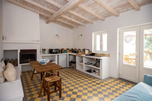a kitchen with a table and a dining room at Monte das Oliveiras - Casas de Campo in Estremoz
