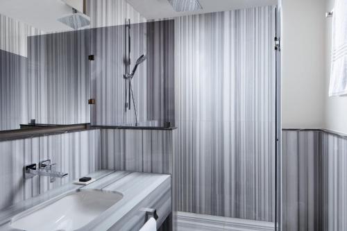 a white bathroom with a sink and a shower at DeCamondo Galata, a Tribute Portfolio Hotel in Istanbul