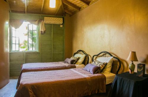 Un dormitorio con dos camas y una ventana. en One32 Guest House, en Kingston