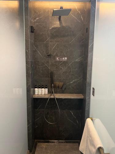 a bathroom with a shower with a shower head at Nostalgia S Hotel Beijing National Stadium-Bird's Nest 时光漫步S酒店北京科技大学鸟巢店 Free fresh ground coffee,Free laundry service in Beijing